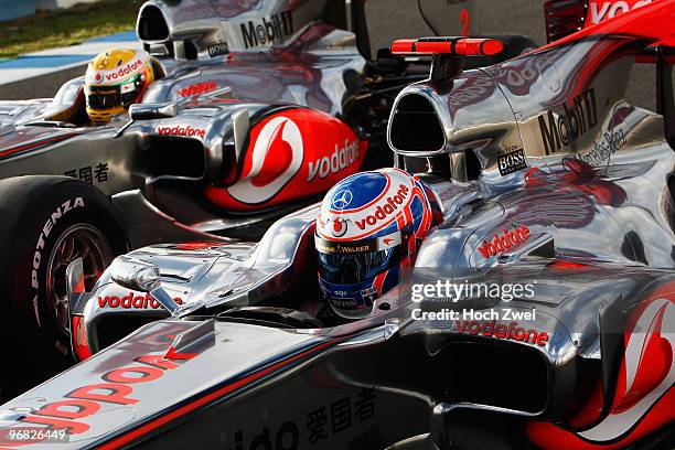 Jenson Button of Great Britain and McLaren Mercedes and Lewis Hamilton of Great Britain and McLaren Mercedes sit side by side in their cars during...