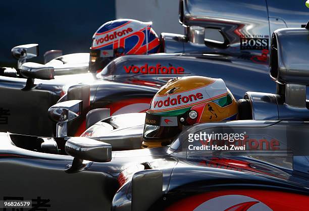 Jenson Button of Great Britain and McLaren Mercedes and Lewis Hamilton of Great Britain and McLaren Mercedes sit side by side in their cars during...