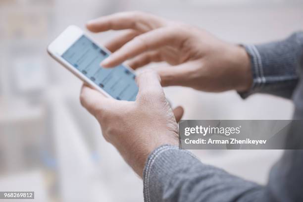 hands of man using smartphone - arman zhenikeyev fotografías e imágenes de stock