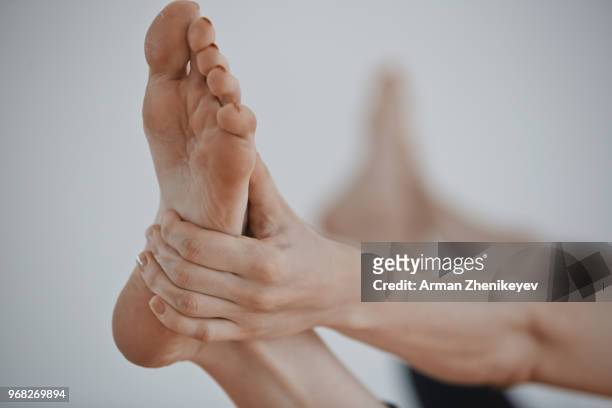feet of the woman doing yoga exercise - arman zhenikeyev stock-fotos und bilder