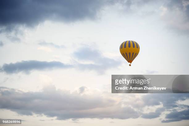 hot air balloon flying in cloudy sky - arman zhenikeyev fotografías e imágenes de stock
