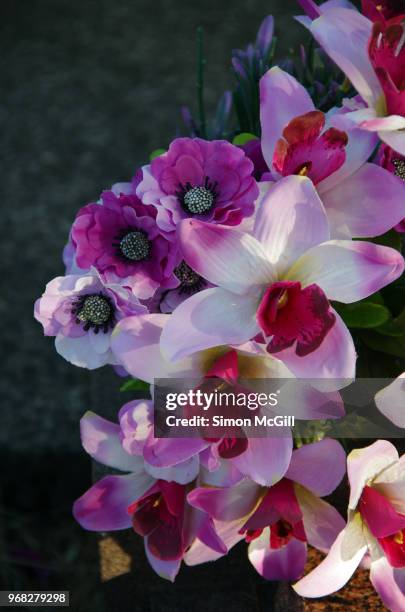bouquet of artificial flowers on a grave - anemone flower arrangements stock pictures, royalty-free photos & images