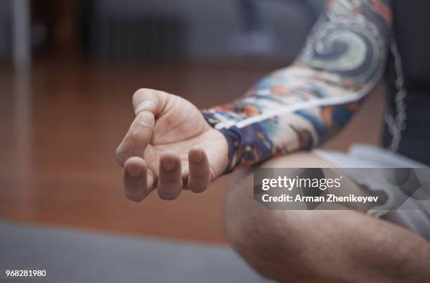 man practicing yoga indoors - arman zhenikeyev photos et images de collection