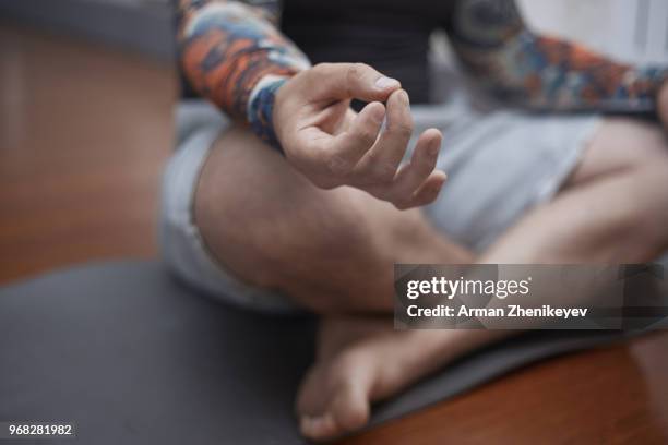 man practicing yoga indoors - arman zhenikeyev stock-fotos und bilder