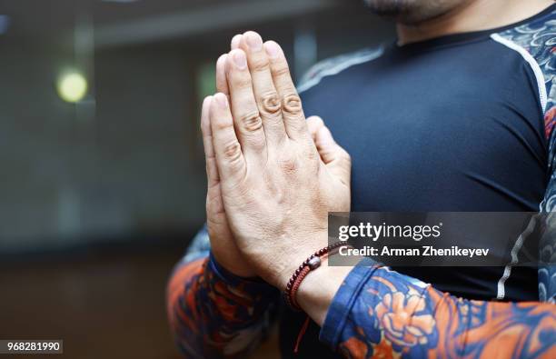 man practicing yoga indoors - arman zhenikeyev stock-fotos und bilder