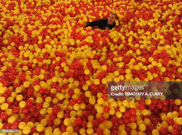 Paul Catzomo searches for a in a ball pit set up in Grand Central Station in New York on February 1, 2010 to promote the largest lottery agreement in...