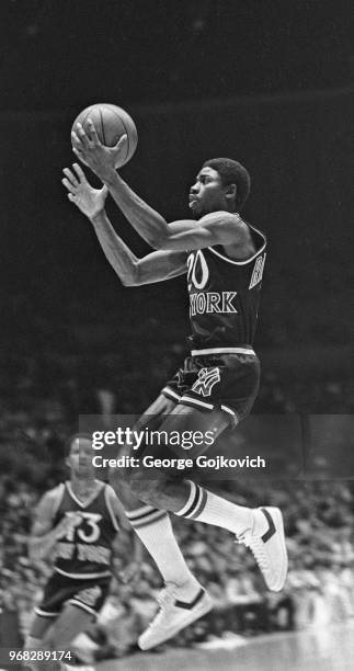 Guard Micheal Ray Richardson of the New York Knicks shoots the basketball as guard Ray Williams looks on during a National Basketball Association...