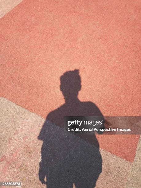 shadow of a men on street background using mobile phone - schatten im mittelpunkt stock-fotos und bilder