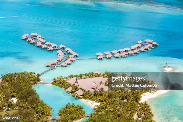 aerial view of overwater bungalows, bora bora, french polynesia - strohgedeckte strandhütte stock-fotos und bilder