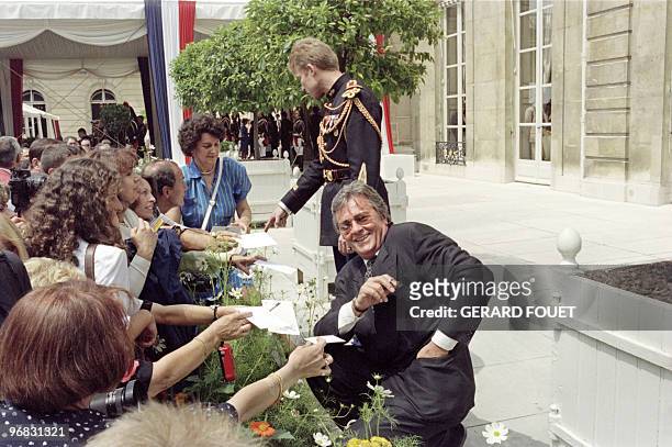 French actor Alain Delon signs autographs on July 14 during Elysée garden party, In 1994, troop of the Eurocorps, including German soldiers, paraded...