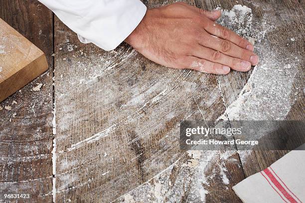 man wiping flour across work surface - kitchen bench wood stock-fotos und bilder