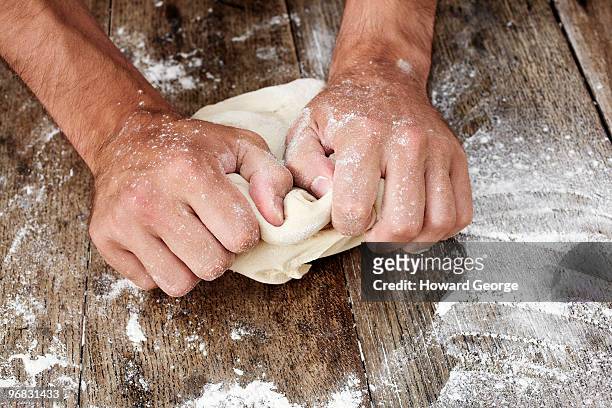 man kneading bread dough - impasto foto e immagini stock