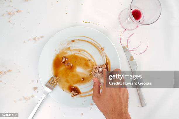 man wiping up sauce from plate - cleaning after party stock pictures, royalty-free photos & images