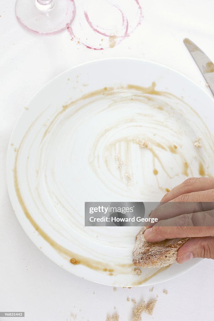 Man wiping up sauce from plate