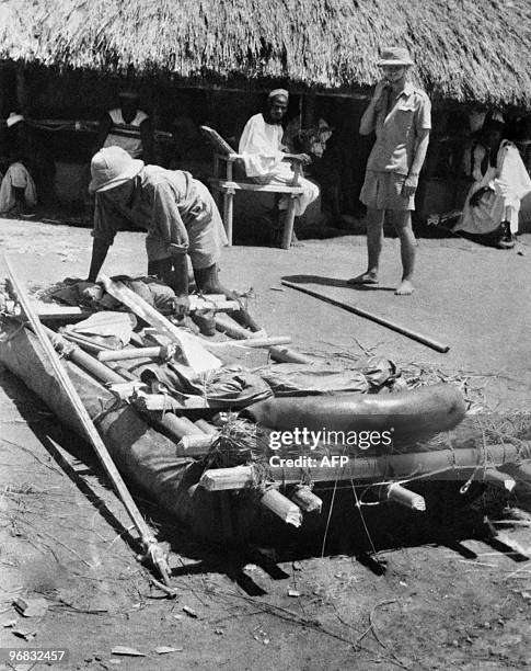 Photo prise en mars 1947 de colons s'apprêtant à embarquer sur un radeau, dans un village africain, aux sources du Niger, en Afrique. Picture taken...