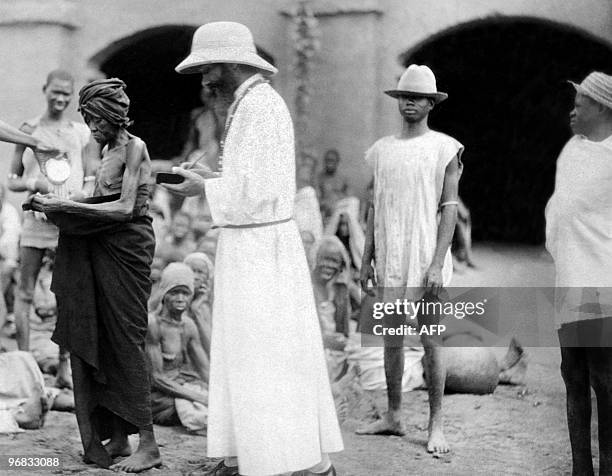 Photo prise dans les années 30 d'un missionnaire parmi une tribu africaine, en Afrique occidentale française . L'Afrique occidentale française était...