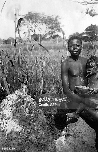 Photo prise dans les années 30 d'une jeune fille et un enfant posant près de l'autel fétiche des Lobi en Afrique occidentale française . L'Afrique...