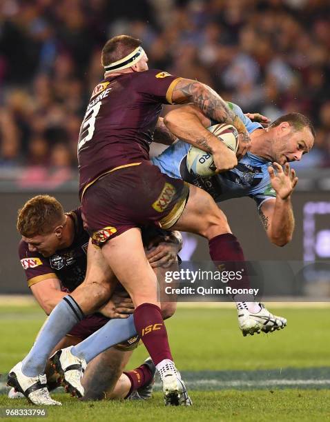 Boyd Cordner of the Blues is tackled by Josh McGuire of the Maroons during game one of the State Of Origin series between the Queensland Maroons and...