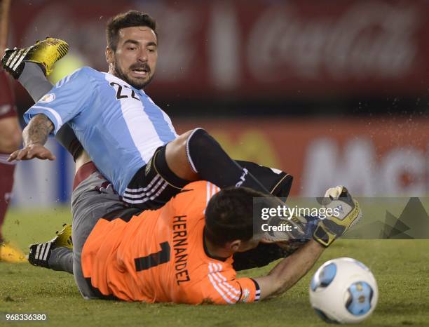 Argentine forward Ezequiel Lavezzi clashes with Venezuelan goalkeeper Daniel Hernandez during a Brazil 2014 World Cup South American qualifier...