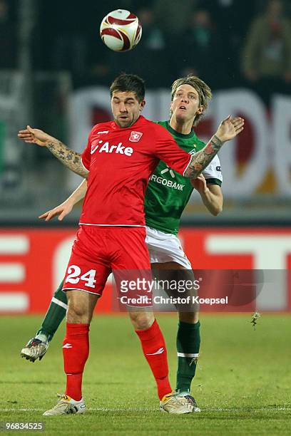 Peter Niemeyer of Bremen tackles Theo Janssen of Enschede during the UEFA Europa League knock-out round, first leg match between FC Twente Enschede...