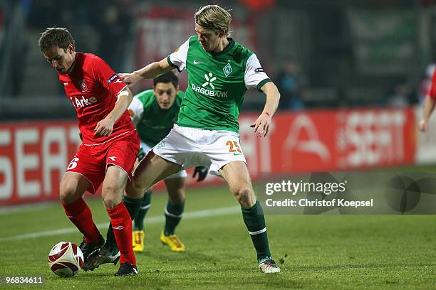 Peter Niemeyer of Bremen tackles Wout Brama of Enschede during the UEFA Europa League knock-out round, first leg match between FC Twente Enschede and...