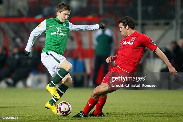 Kenneth Perez of Enschede tackles Marko Marin of Bremen during the UEFA Europa League knock-out round, first leg match between FC Twente Enschede and...