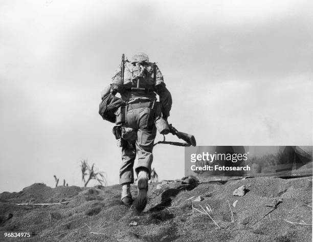 Photograph of a Fifth Division Marine in Full Battle Gear Under Enemy Fire on Iwo Jima, February 19th, 1945.