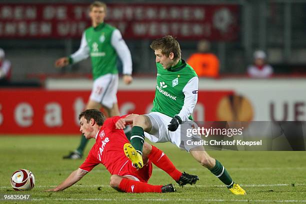 Wout Brama of Enschede tackles Marko Marin of Bremen during the UEFA Europa League knock-out round, first leg match between FC Twente Enschede and SV...