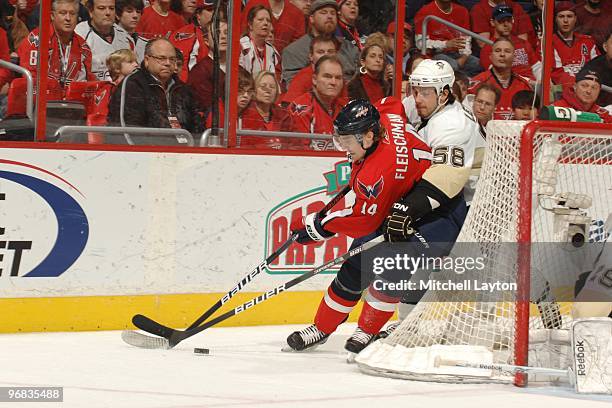 Tomas Fleischmann of the Washington Capitals tries to control the during a NHL hockey game against Kris Letang of the Pittsburgh Penguins on February...