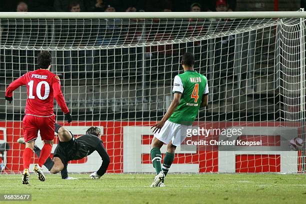 Tim Wiese of Bremen gets the first goal of Theo Janssen of Enschede during the UEFA Europa League knock-out round, first leg match between FC Twente...
