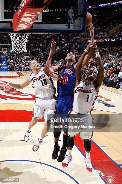 Jared Jeffries of the New York Knicks goes for the rebound against Anthony Parker and Daniel Gibson of the Cleveland Cavaliers during the game on...