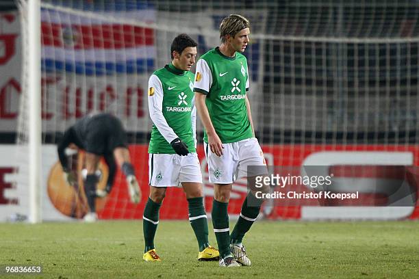Mesut Oezil of Bremen and Peter Niemeyer of Bremen look dejected after the first goal during the UEFA Europa League knock-out round, first leg match...