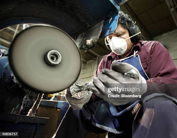 Alvaro Landa uses a buffing wheel on a freshly cast Oscar statuette at the R.S. Owens & Co. Factory in Chicago, Illinois, U.S., on Thursday, Feb. 18,...