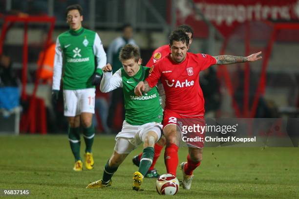 Theo Janssen of Enschede tackles Marko Marin of Bremen during the UEFA Europa League knock-out round, first leg match between FC Twente Enschede and...