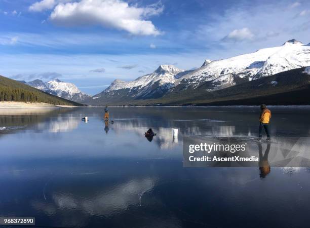 eis-fischer am zugefrorenen see in den bergen - see lake minnewanka stock-fotos und bilder