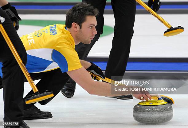 Sweden's third Sebastian Kraupp throws the stone during their round robin match against Canada in the Vancouver Winter Olympic men's curling games at...
