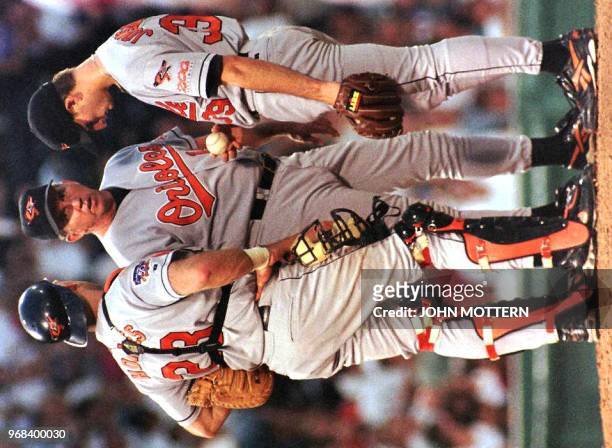 Baltimore Orioles pitcher Mike Johnson talks with manager Davey Johnson and catcher Chris Hoiles during the third inning of Baltimore's game against...