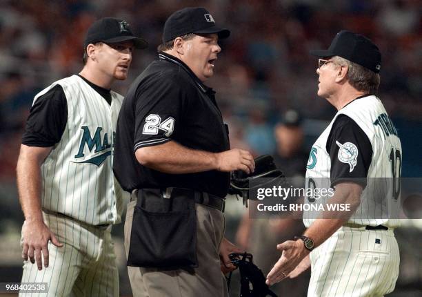 Florida Marlins' pitcher Ryan Dempster stands back as Marlins' manager Jeff Torborg argues with homeplate umpire Jerry Layne after Lanyne threw...