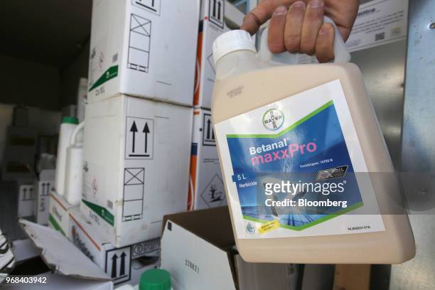 Farmer takes a bottle of Betanal Maxx Pro herbicide from a storage area on a farm in Abbenes, Netherlands, on Wednesday, June 6, 2018. After waiting...