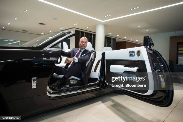 TTorsten Muller-Otvos, chief executive officer of Rolls-Royce Motor Cars Ltd., sits for a photograph in a Rolls-Royce Dawn convertible vehicle after...