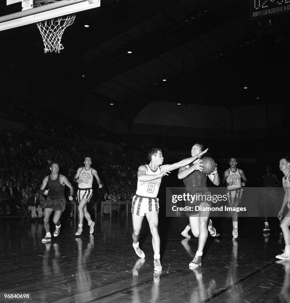 Forward Harry Gallatin of the New York Knicks drives towards the basket as Guard Bobby Wanzer of the Rochester Royals tries to defend on the play...
