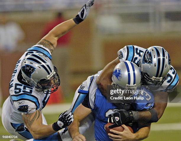 Detroit Lions quarterback Joey Harrington is tackled by Dan Morgan and Brentson Buckner versus the Carolina Panthers at Ford Field, Oct. 16, 2005....