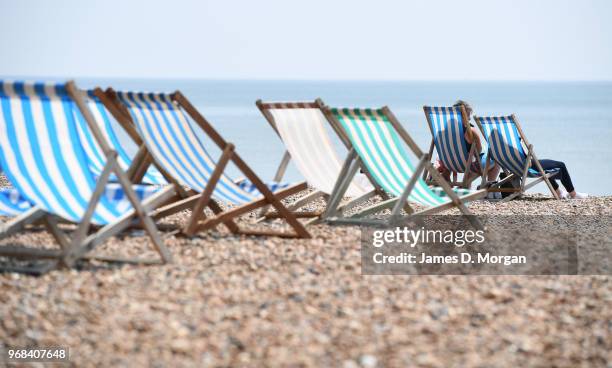 Two people sunbathe on the beach on June 6, 2018 in Brighton, England. Temperatures in Brighton reached 21 degrees celcius, 70 degrees fahrenheit as...