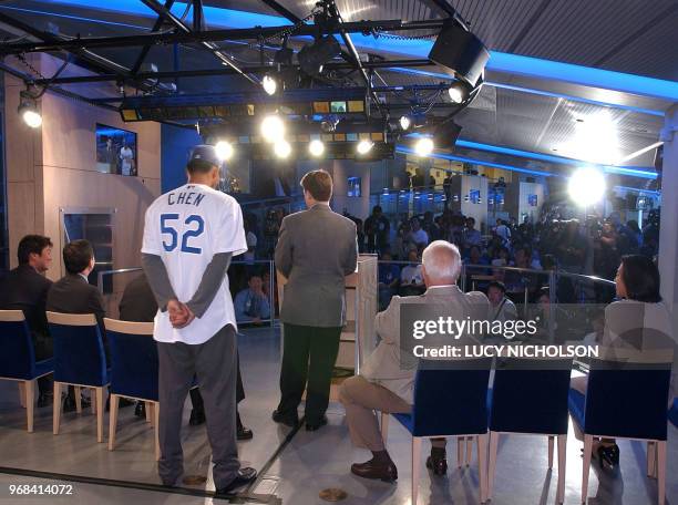 Taiwanese player Chin-Feng Chen listens as Los Angeles Dodgers general manager Dan Evans speaks at a press conference to welcome him to the Dodgers,...