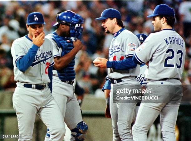 Glenn Hoffman , the new manager of the Los Angeles Dodgers walks away from the mound after bringing in relief pitcher Jim Bruske as teammates Charles...