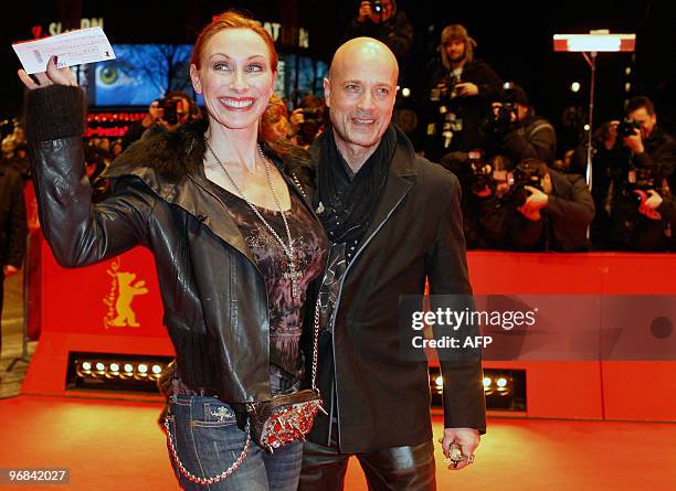 German actress Andrea Sawatzki waves cinema tickets as she and German actor Christian Berkel arrive on the red carpet at the premiere of the film...
