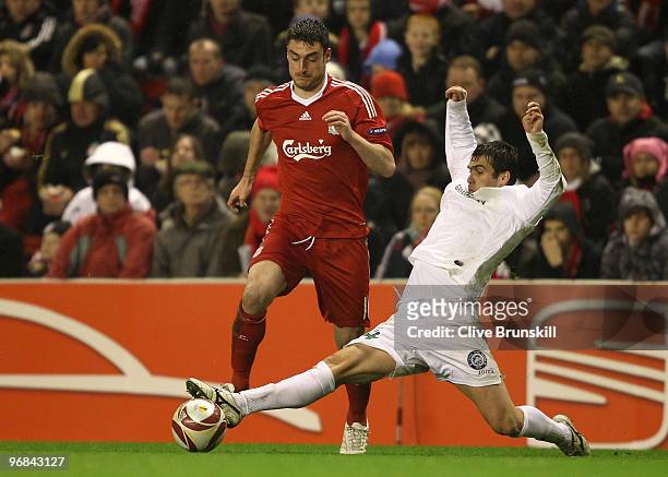 Albert Riera of Liverpool attempts to avoid a tackle from Vasile Maftei of Unirea Urziceni during the UEFA Europa League Round 32 first leg match...