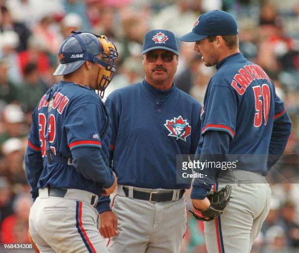 Toronto Blue Jays catcher Kevin Brown and manager Tim Johnson take time out to talk to pitcher Chris Carpenter during the third inning of a spring...