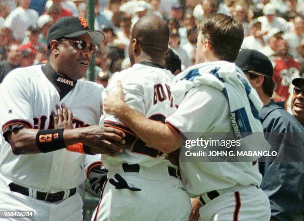 Manager Dusty Baker and J.T. Snow of the Giants hold back team-mate Barry Bonds after Bonds started arguing with Pittsburgh Pirates batting coach...