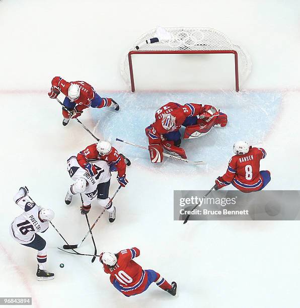 Joe Pavelski of the United States battles for control of the puck along with teammate Ryan Malone during the ice hockey men's preliminary game...